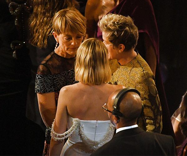 Good sports! Margot Robbie and her mum talk to fellow Best Actress nominee, Frances McDormand.