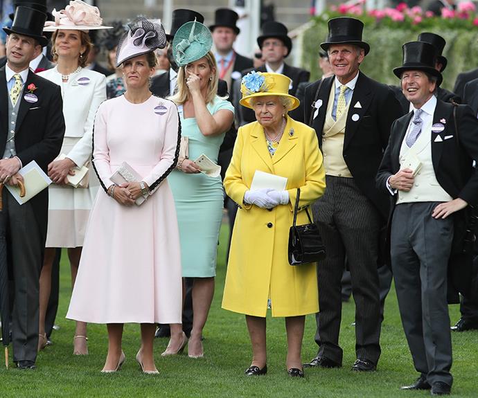 She's a keen racer! Queen Elizabeth stands with John Warren as they watch the Wolferton Rated Stakes race.