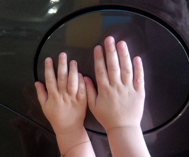 Bell is always happy to share a parent hack. By asking their kids to put their hands on the circle of the fuel tank on the side of their car, they keep their girls safe in carparks. Bell writes, "'Hands on the circle' has has thus far kept all kiddos safe from any oncoming traffic while I unload the trunk." *Image: Instagram/KristenAnnieBell*