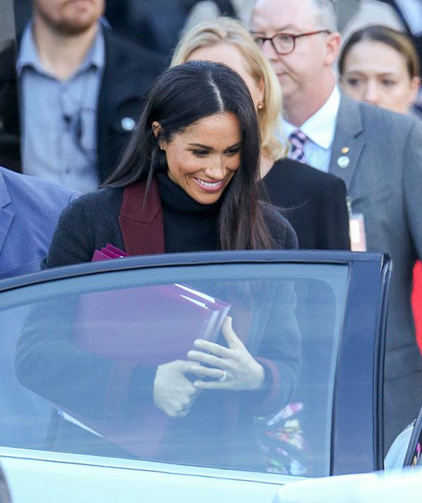 Spotted! Meghan [officially landed on Australian shores](https://www.nowtolove.com.au/royals/british-royal-family/prince-harry-meghan-markle-arrive-sydney-51819|target="_blank") with Prince Harry on Monday morning. Along with a black and maroon coat, the strategic placement of two large folders across her stomach sent the pregnancy rumours into overdrive. Later that day, all was [confirmed](https://www.nowtolove.com.au/royals/british-royal-family/meghan-markle-pregnant-51548|target="_blank")! *(Image: Media Mode)*