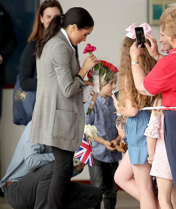 Meghan stops to smell the roses, quite literally.