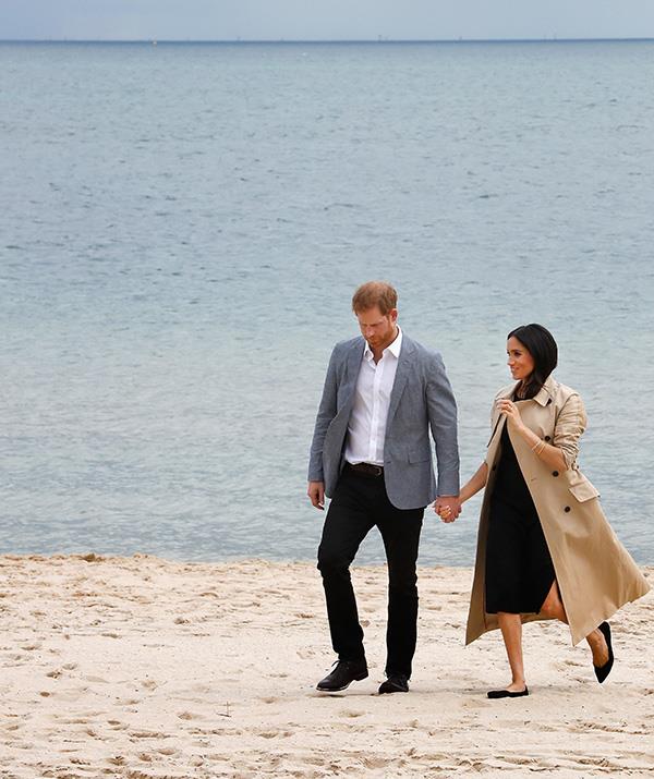 The Duchess made a quick outfit change ahead of their visit to the beach. She wore a black Club Monaco dress paired with her tour-favourite camel trench coat by Martin Grant - and a pair of flats. *(Image: Getty Images)*