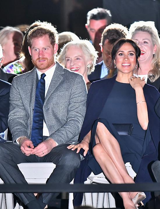 A wild thunderstorm on Saturday evening didn't faze Meghan as she stepped out for the (slightly delayed) opening ceremony in a navy blue Stella McCartney dress. Stella is one of Meghan's favourite designers - she also created the Duchess's [beautiful high-neck sleeveless halter gown for her post-wedding reception](https://www.nowtolove.com.au/fashion/fashion-news/meghan-markle-second-royal-wedding-dress-48442|target="_blank").  *(Image: Getty Images)*