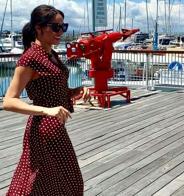 Pretty woman indeed! Meghan looks radiant in a red polka dot dress by British label & Other Stories as she arrived in Queensland on Monday for a day on Fraser Island. *(Image: Instagram / @herveybayecomarinetours)*