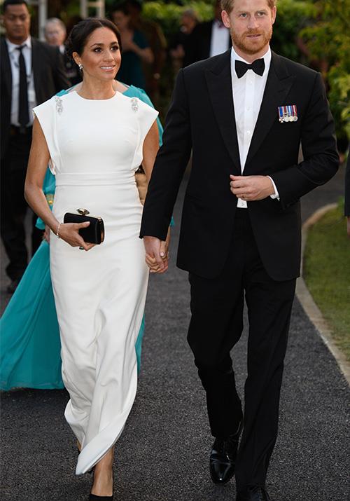 Stepping out for a private evening soiree in Tonga with King Tupou VI and Queen Nanasipauʻu, Duchess Meghan and Prince Harry were a sight to behold - and we couldn't ignore the [striking resemblance to their wedding day style](https://www.nowtolove.com.au/royals/british-royal-family/meghan-markle-prince-harry-tonga-white-dress-52049|target="_blank")! *(Image: Getty Images)*