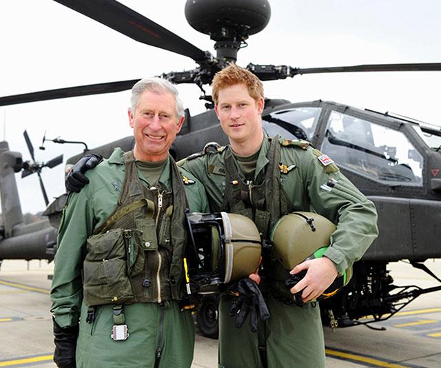 **Moving up the ranks:** A proud Prince Charles poses with Prince Harry following his son's promotion to captain of an Apache Helicopter in 2011. *(Image: Getty)*