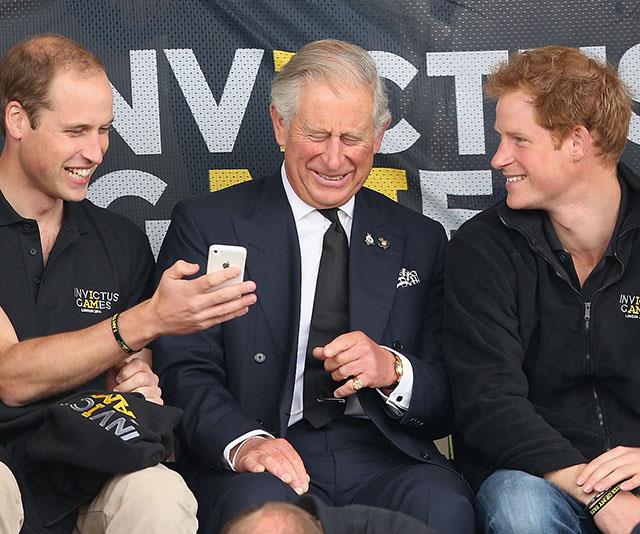**Royal flush:** We'd love to know what's on that phone! The boys have their dad in a fit of giggles at the 2014 Invictus Games in London. *(Image: Getty)*