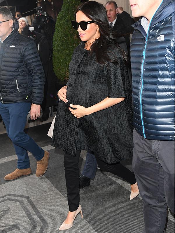 The pregnant royal cradled her baby bump and was positively glowing. *(Image: REX Features)*