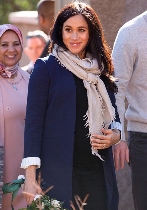 Rugging up! Meghan popped on a Wilfred scarf and black top between engagements during the day. *(Image: Getty Images)*
