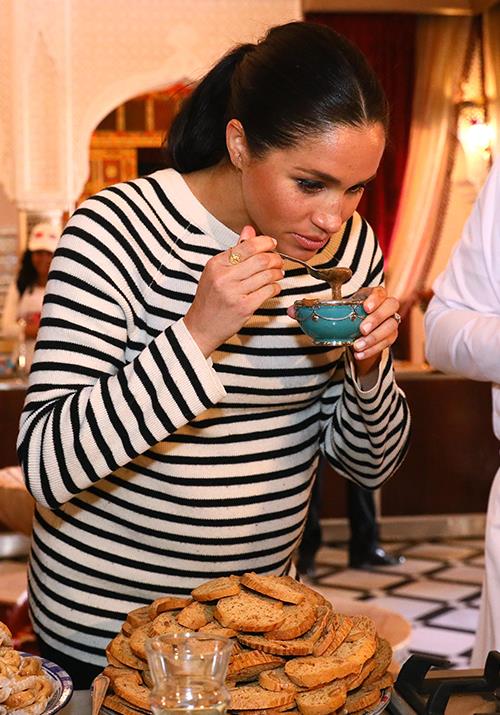 Meghan delighted in tasting some of the chef's delicacies. *(Image: Getty)*