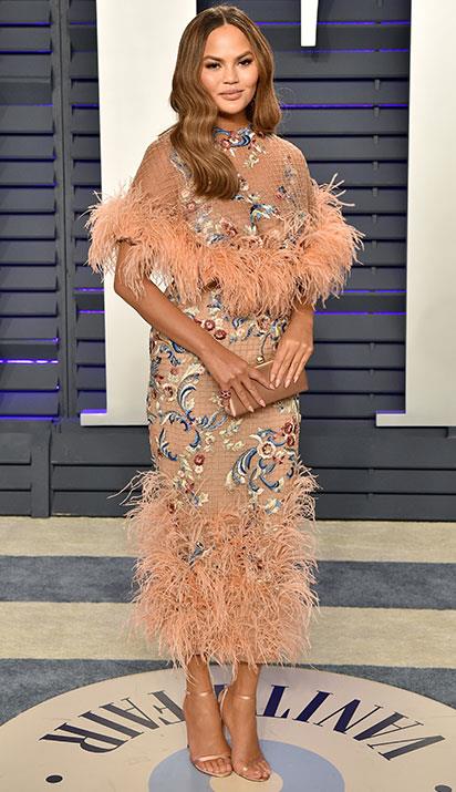 Chrissy's feathered peach frock is all kinds of chic. *(Image: Getty)*
