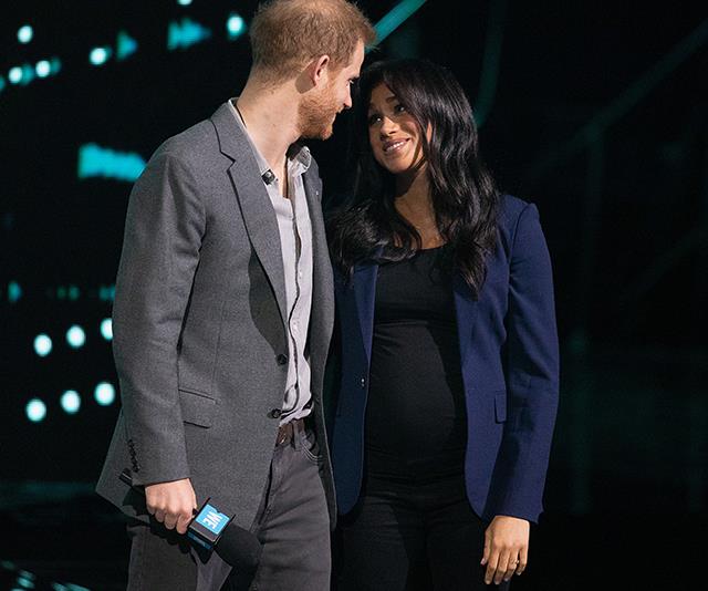 The look of love! Duchess Meghan and Prince Harry couldn't have looked more besotted in a surprise appearance on-stage. *(Image: Getty)*