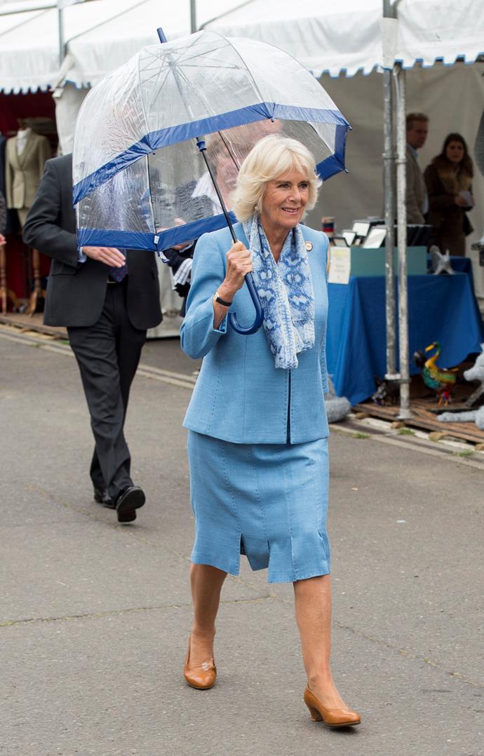 Camilla channelling the Queen with a matching umbrella and suit combo. *(Image: Getty)*