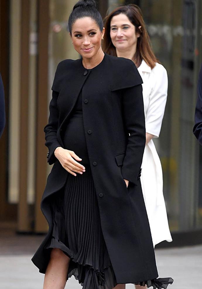 Meghan's black Givenchy coat made the royal look powerful and feminine. *(Image: Getty)*