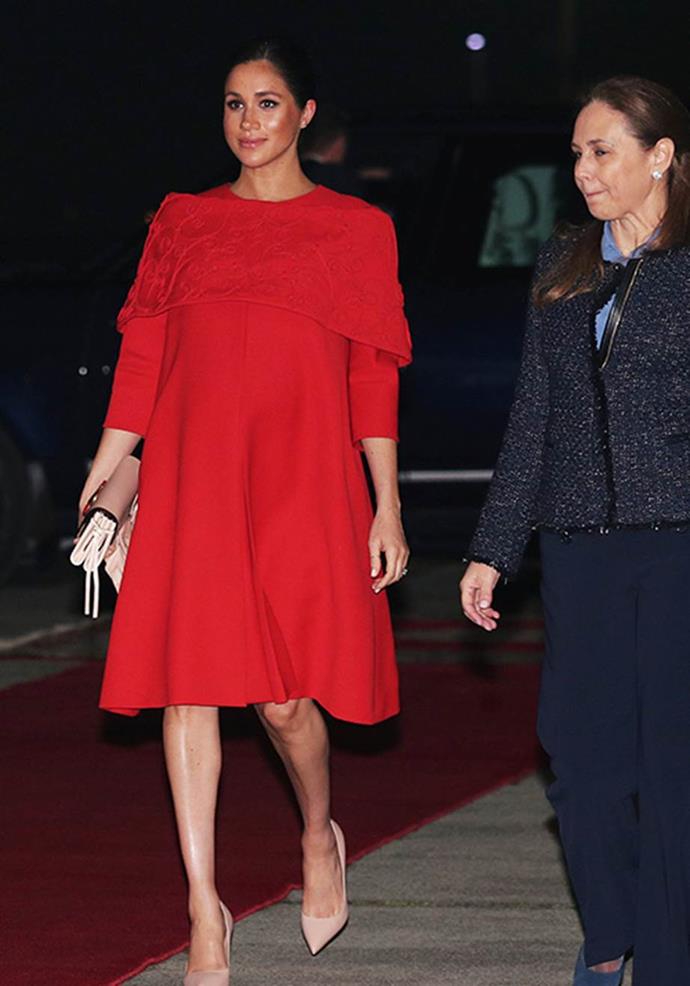 Meghan's Valentino dress in signature red was perfect for her touchdown in Morocco as she entered her third trimester of pregnancy. *(Image: Getty)*