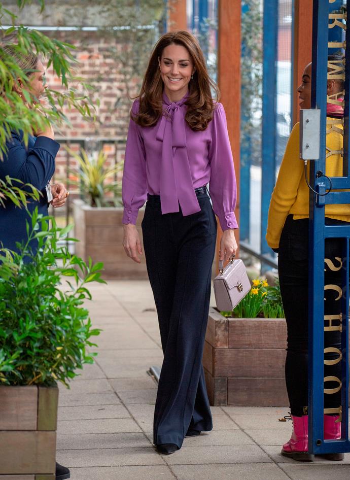 In March 2019, Kate [visited a children's centre](https://www.nowtolove.com.au/fashion/fashion-news/kate-middleton-purple-blouse-54621|target="_blank") wearing a stylish pair of black wide-legged jigsaw pants. Paired with a Gucci blouse and a glam mini bag, this look was all class! 