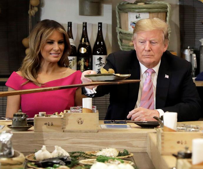 Trump ticks into a baked potato, while Melania just .... looks at it.
