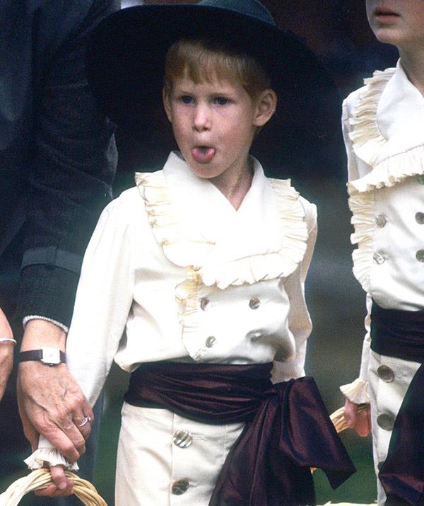 He's at it again! In 1989, Prince Harry donned some serious glad rags as Page Boy at a wedding, but some fancy gear didn't stop him from making the cheeky gesture.