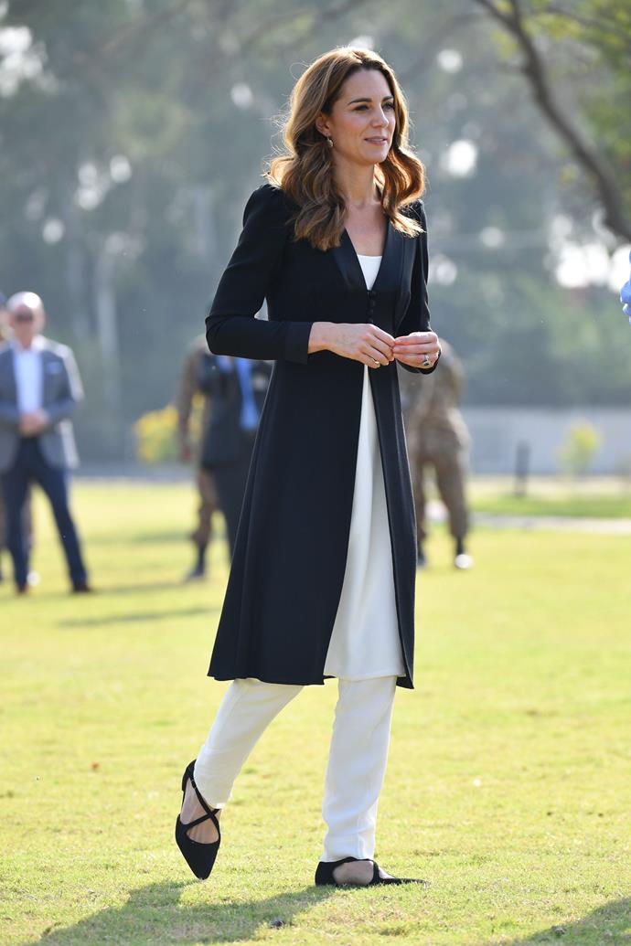 On her fifth and final day of the tour, Kate looked chic in a [black longline coat](https://www.nowtolove.com.au/royals/british-royal-family/kate-middleton-prince-william-pakistan-tour-video-59862|target="_blank") by Beulah London. She paired it with some crisp white trousers by Gul Ahmed and Russell & Bromley flats to finish the look.