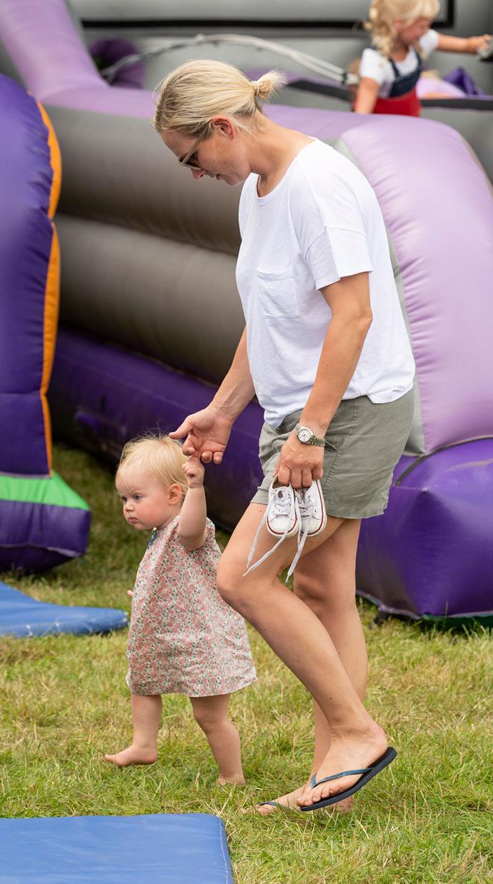 Zara walks daughter Lena Tindall around the jumping castles at the 2019 Festival of British Eventing at Gatcombe Park in August 2019.
