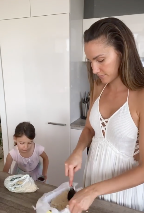 Wellness advocate Rachael Finch gets busy in the kitchen with daughter Violet in a flowing white dress. The perfect mix of comfortable and stylish, the only thing missing here is an apron - risky business wearing white in the kitchen!