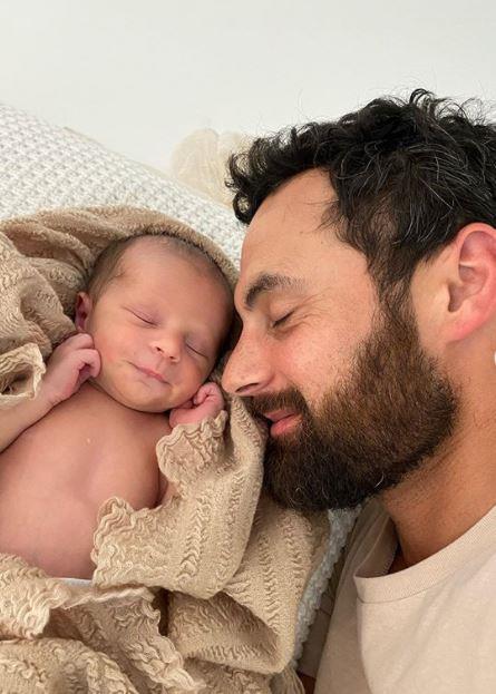 Cam is clearly smitten - he shared two adorable pics of himself and his new son cuddling up, writing: "Loving my new little napping partner"