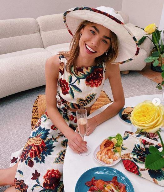 Model Bambi Northwood-Blyth dressed up in her backyard in this stunning floral dress with a matching soft brimmed hat.