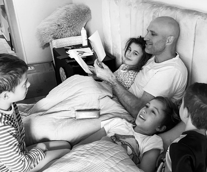 Bec Judd shared a sweet black-and-white snap of her husband, Chris Judd, reading to their kids in bed.
<br><br>
"Happy days," she simply captioned the post. "Love you our King."
