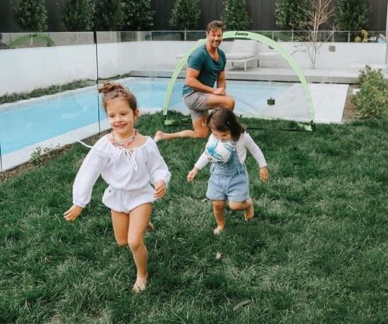 The girls have plenty of room to play with mum and dad in the lavish backyard of their Melbourne home.