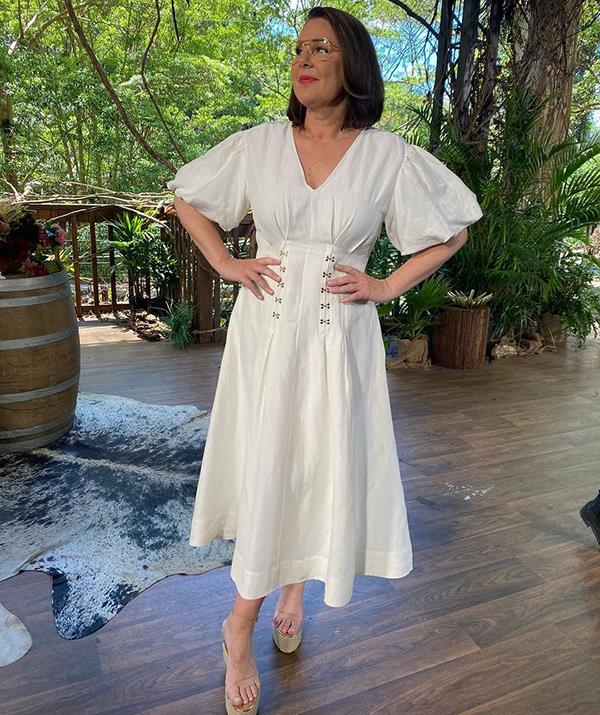 Julia opted for a midi dress by old-faithful Aussie brand Country Road during the 2022 return of *I'm a Celeb*.
<br><br>
For a pop of colour, the TV personality added a bold red lip, and kept her signature glasses simple with clear frames.