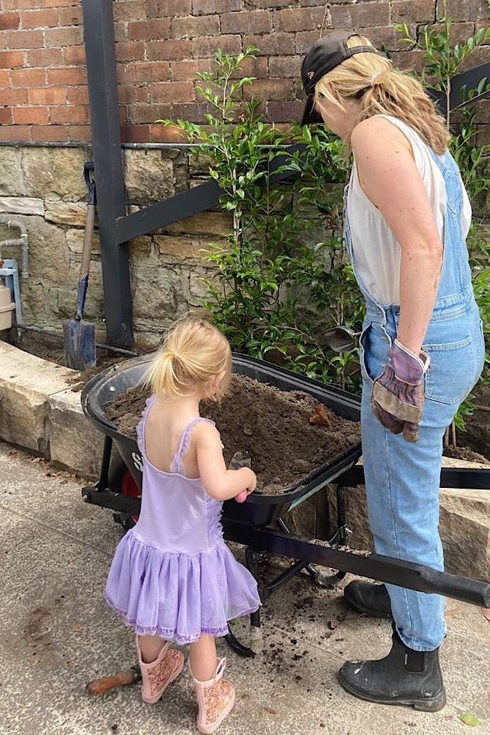 Neve and Penny garden together! The toddler is so precious helping in her rain boots.