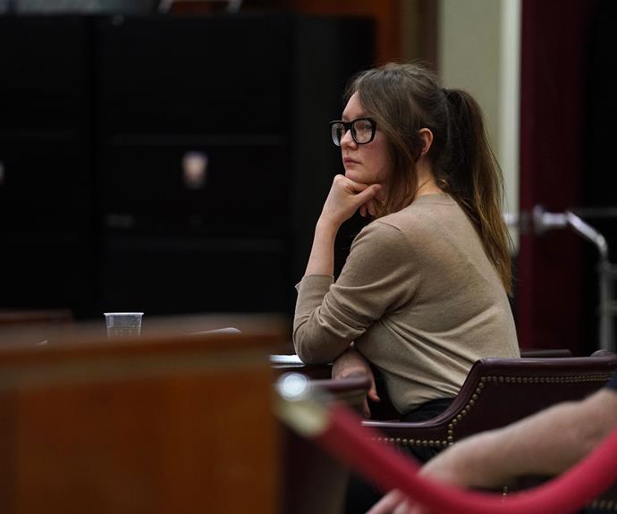 Anna sits and waits for her legal team in court.