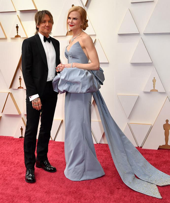 Nicole Kidman poses with husband Keith Urban on the 2022 Academy Awards red carpet in a gown by Armani Privé.