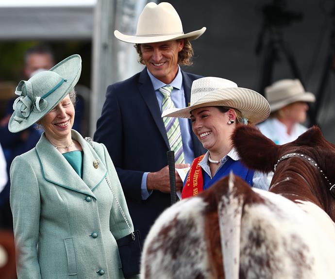 Princess Anne laughs with locals after handing out winners' ribbons to some of the prize cattle.