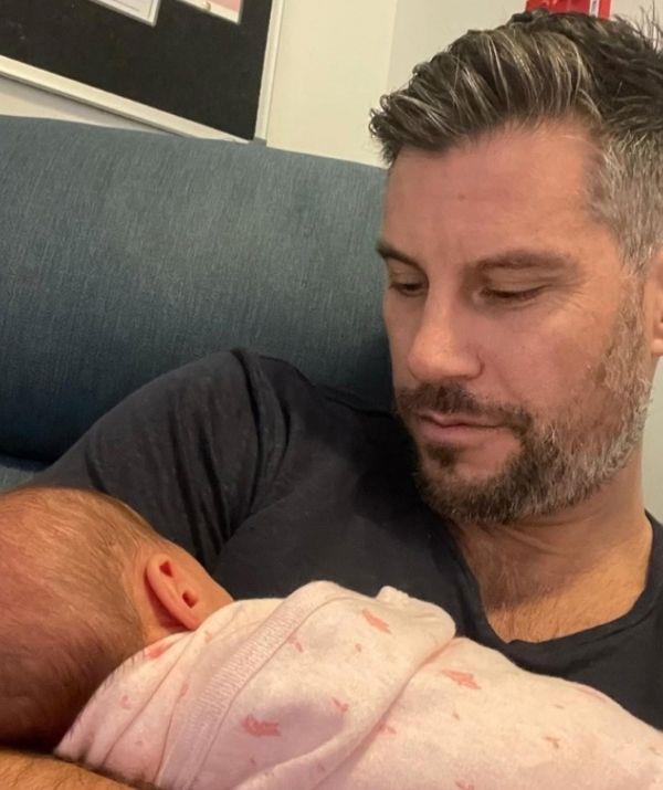 Sam cuddled up to baby daughter Harper in hospital.