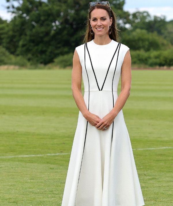 While attending a royal charity polo match in Windsor, the Duchess of Cambridge was the picture of elegance in this white, mid-length, Emilia Wickstead Denvella dress accompanied by green tortoise sunglasses, brown hooped earrings and beige pumps.