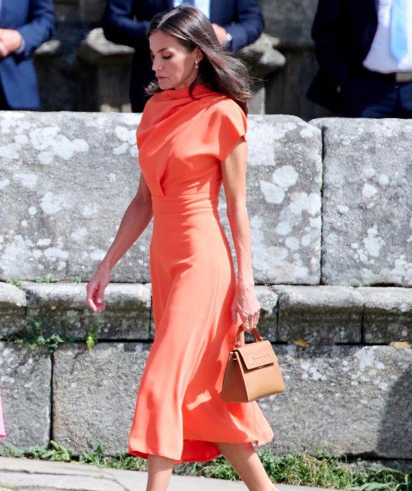 In July 2022, Queen Letizia looked radiant in this bold, orange, [high neck Vogana Mer dress](https://www.nowtolove.com.au/fashion/fashion-trends/queen-letizia-dresses-57524|target="_blank"), accessorised with a Carolina Herrera satchel bag and camel suede pumps.