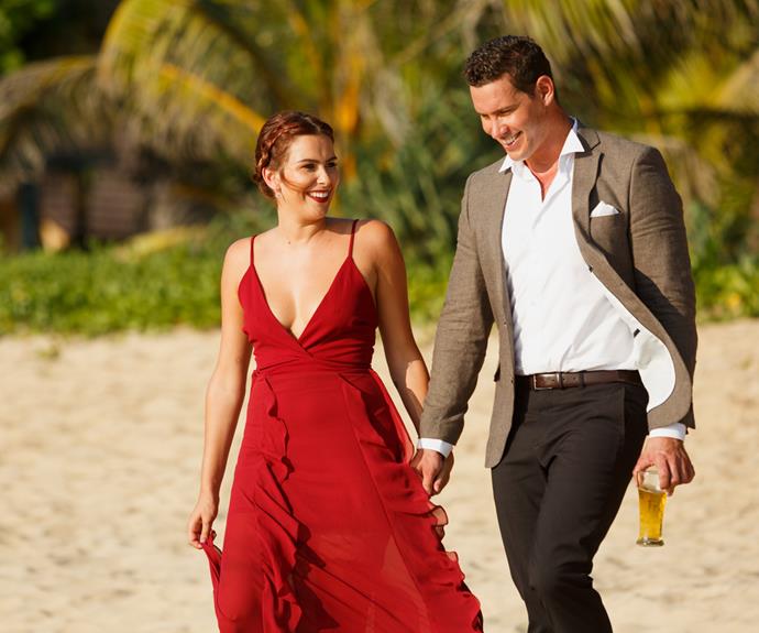 The pair take a romantic stroll on the beach before a rose ceremony in Thailand.