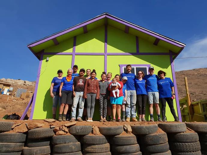 Art and the rest of the Volunteer Build team proudly stand outside the home they built - along with the new homeowners. *Photo: Emily Hlavac Green*