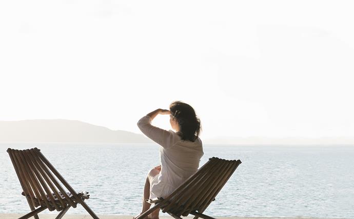 Woman on deck chair stares out to horizon