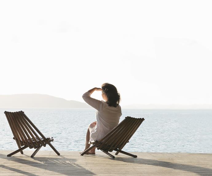 Woman on deck chair stares out to horizon