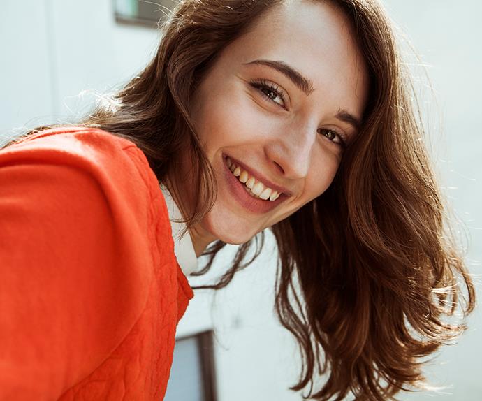brunette girl smiling in red top