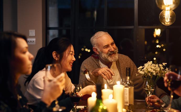 people of all ages round a table at dinner party