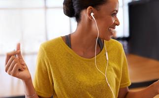 happy woman dancing listening to music on earphones