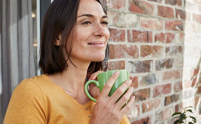 brunette woman smiling drinking coffee