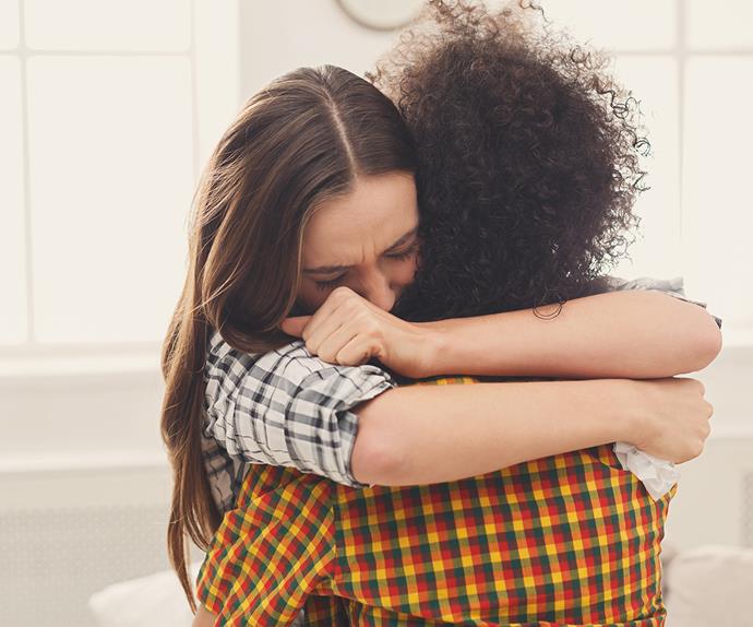 woman hugging friend sad