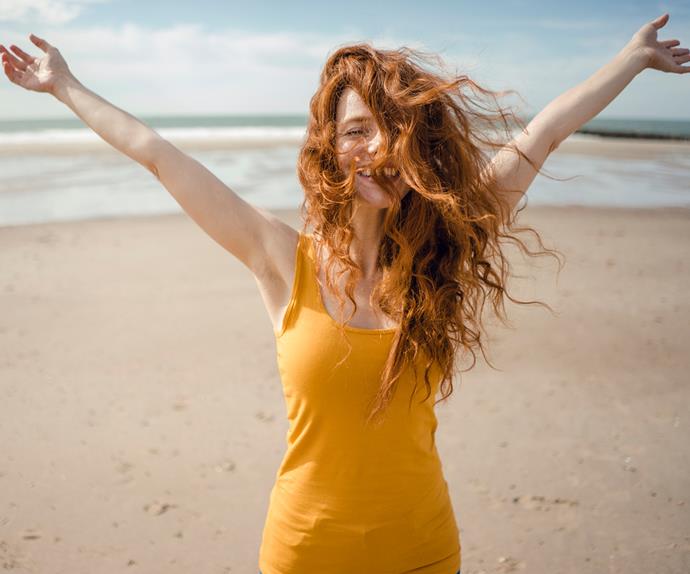 Redheaded woman, laughing happily in the wind