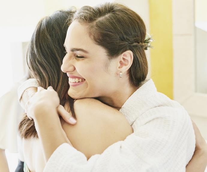 Two brunette woman smiling hugging
