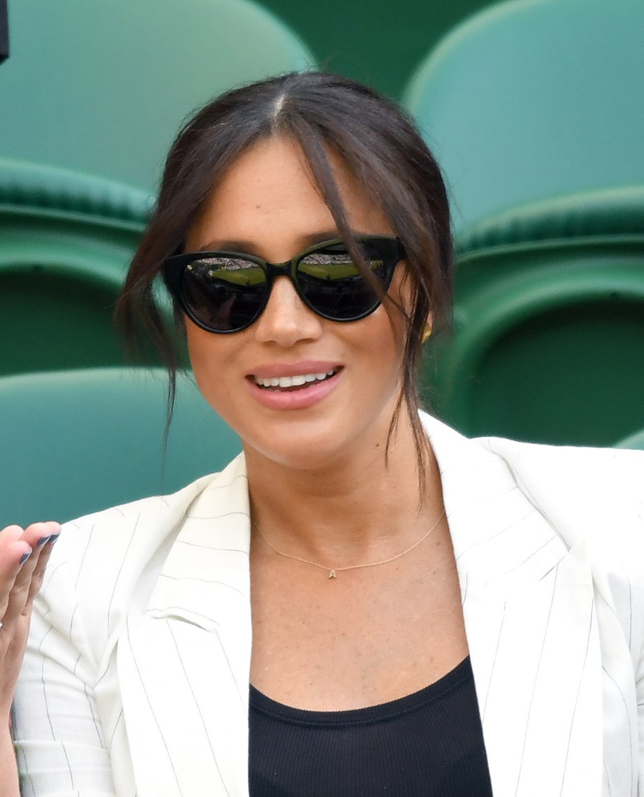 A delicate gold necklace with an 'A' was spotted around Meghan's neck at Wimbledon on July 4th. *(Image: Getty)*