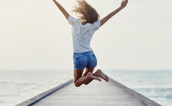 woman full of energy jumping on a pier